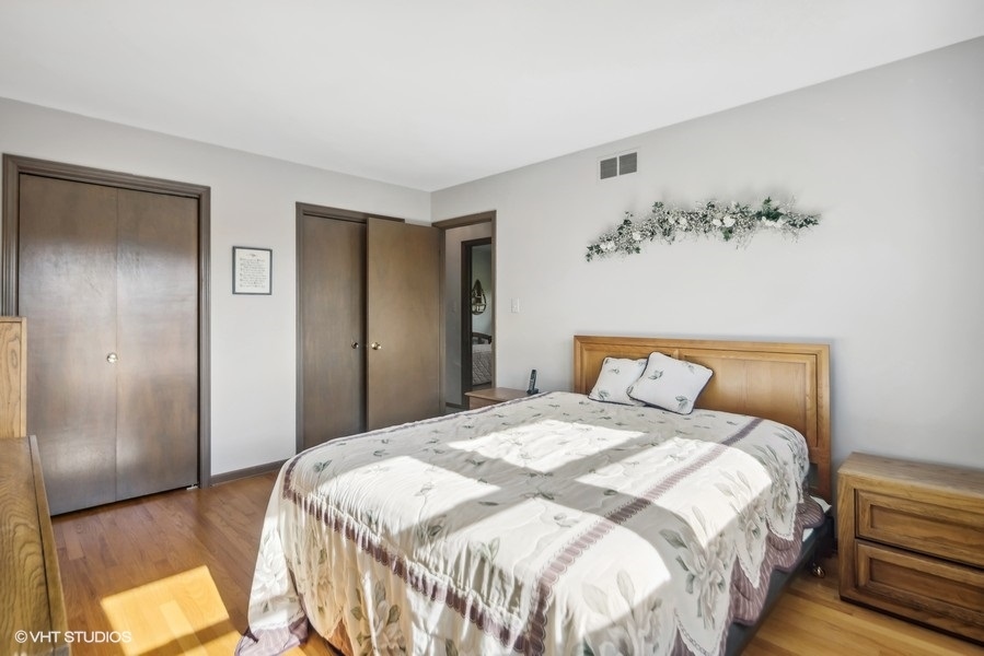 7631 Apple Tree Lane Willowbrook, IL 60527 - Photo 4 of 24 a bedroom with a bed and a chandelier