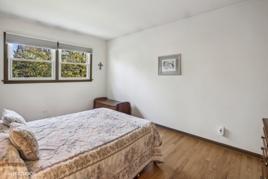 7631 Apple Tree Lane Willowbrook, IL 60527 - Photo 6 of 24 a bedroom with a bed and a window