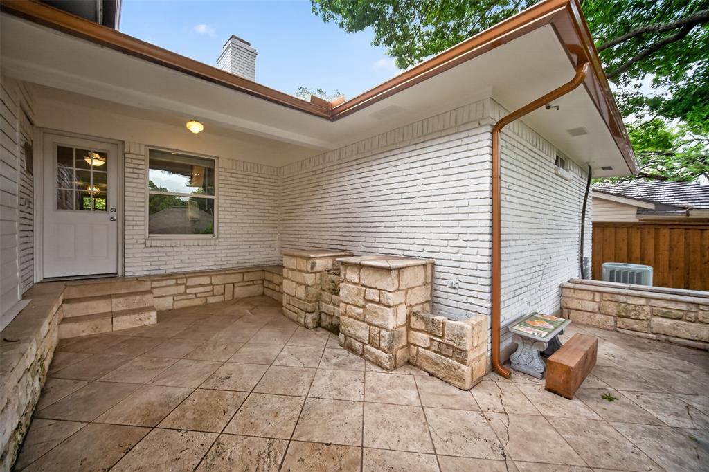 9660 Timberleaf Drive Dallas, TX 75243 - Photo 39 of 40 Covered patio featuring stamped concrete flooring and a white brick exterior