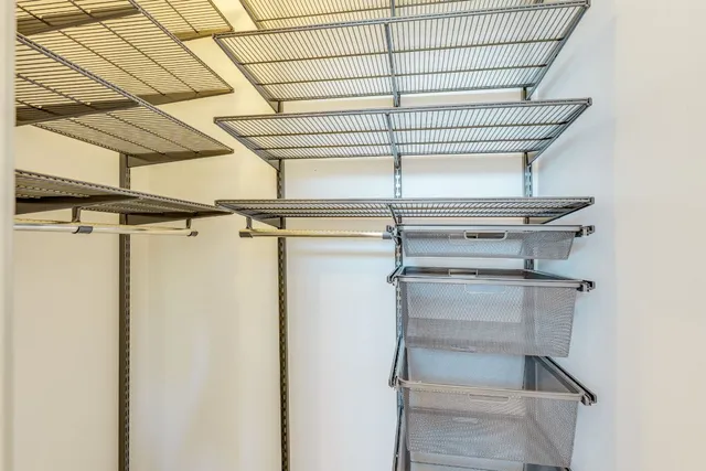 a view of walk in closet with empty racks