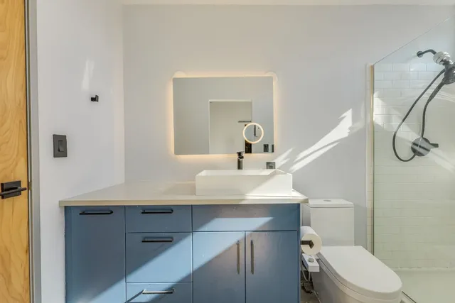 a bathroom with a sink a toilet and shower