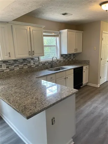 a kitchen with sink window and cabinets