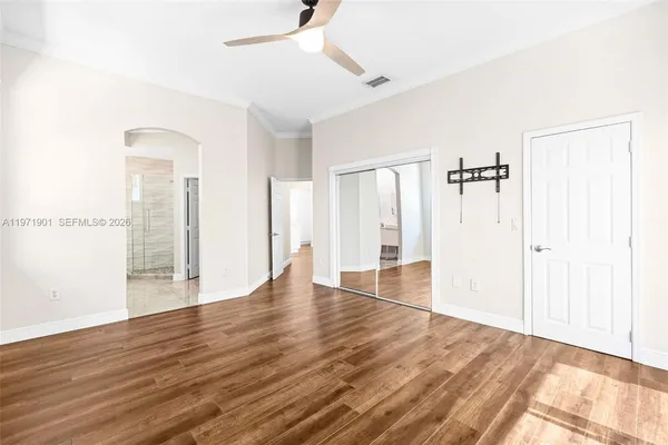 a view of an empty room with wooden floor