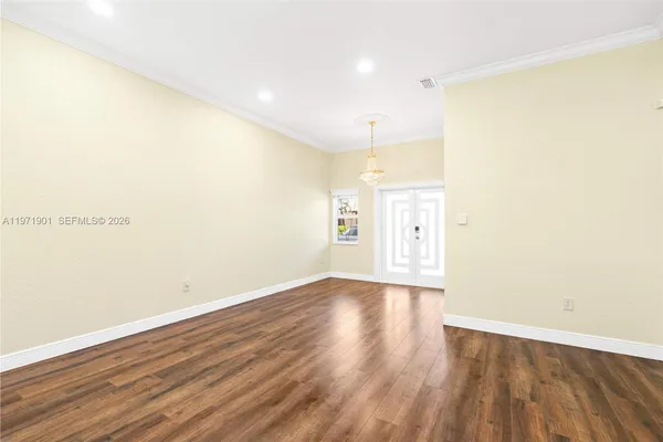 a view of an empty room with wooden floor