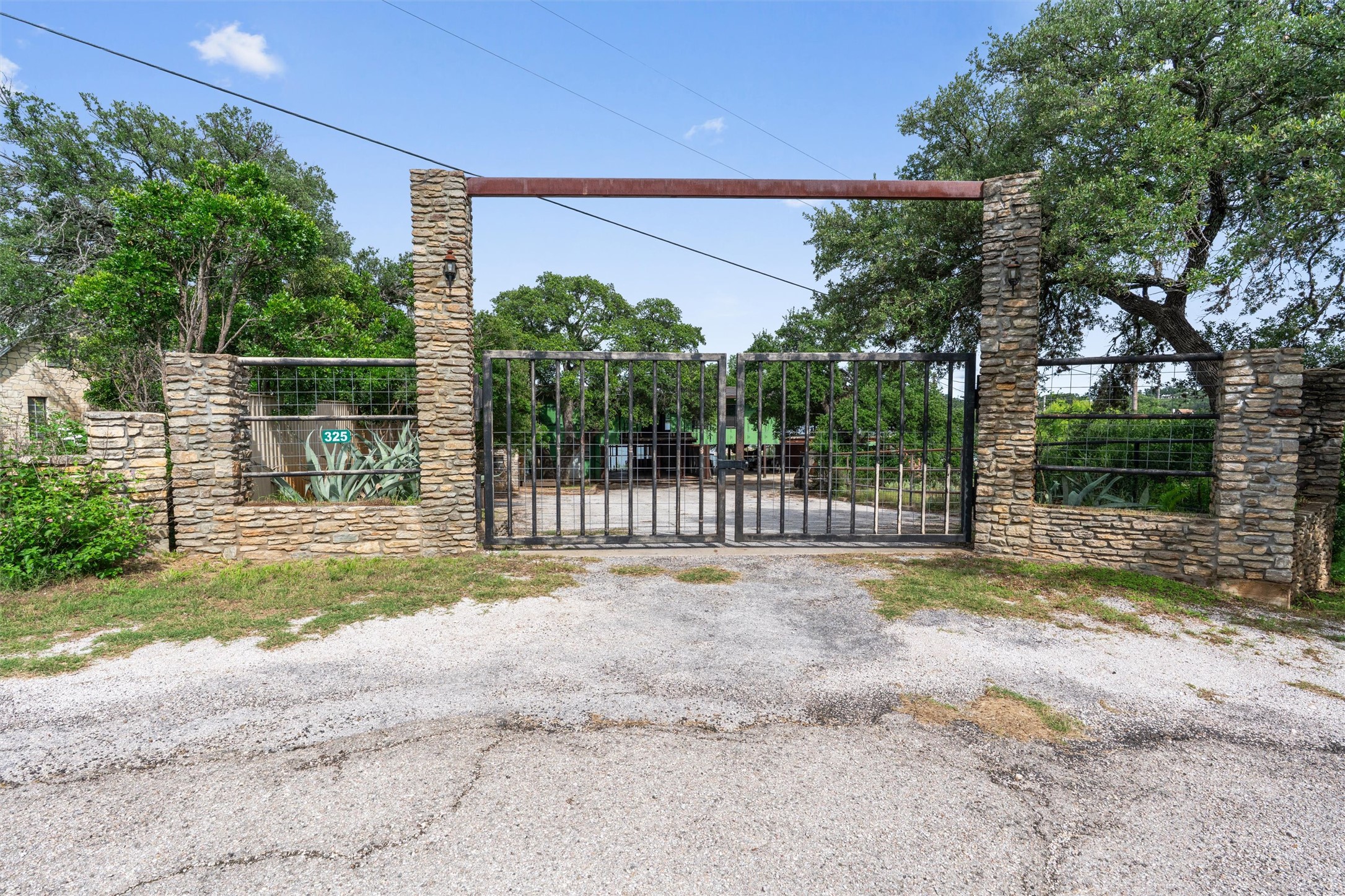 325 Eagle Rest Burnet, TX 78611 - Photo 40 of 40 A grand gated entrance featuring stone columns and mature trees, offering privacy and curb appeal.