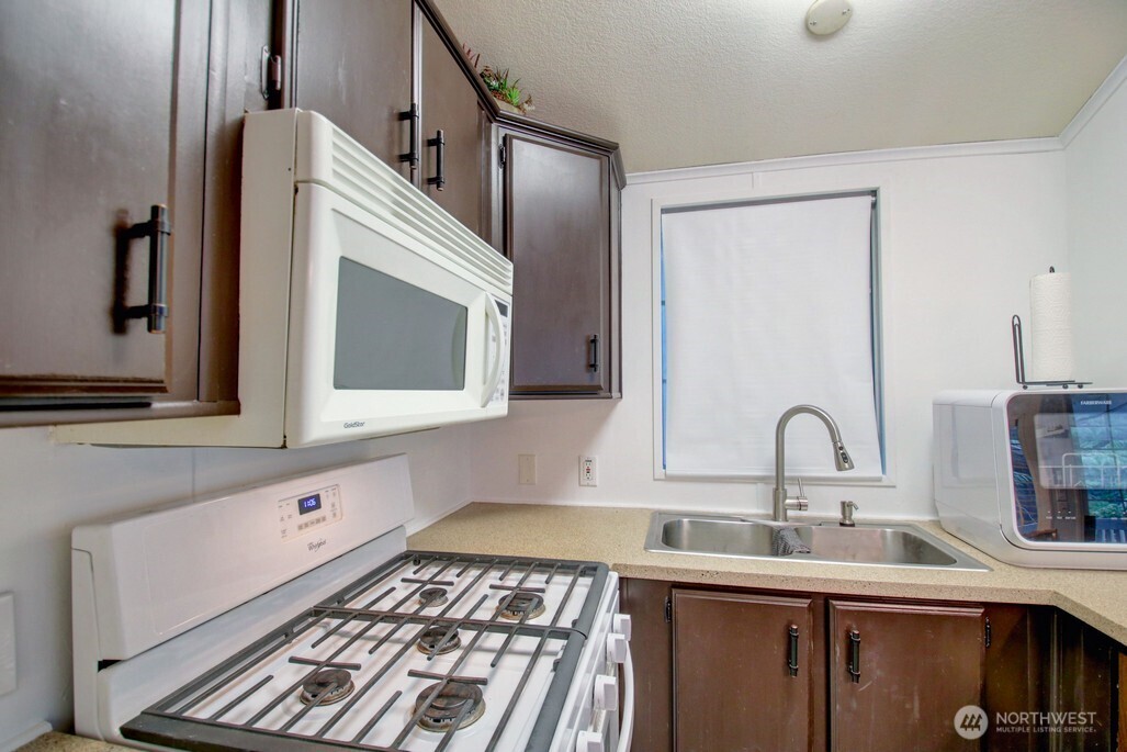 35 Branch Circle Maple Falls, WA 98266 - Photo 17 of 37 a kitchen with a sink and a stove with wooden floor