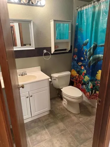 a bathroom with a toilet sink and mirror