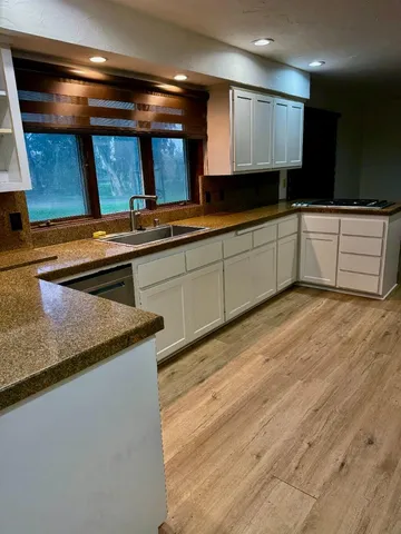 a kitchen with granite countertop a sink and cabinets
