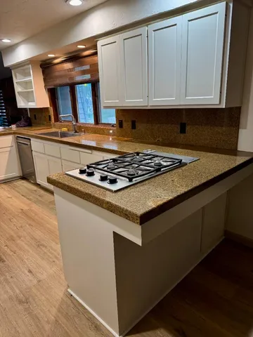 a kitchen with granite countertop a stove and cabinets