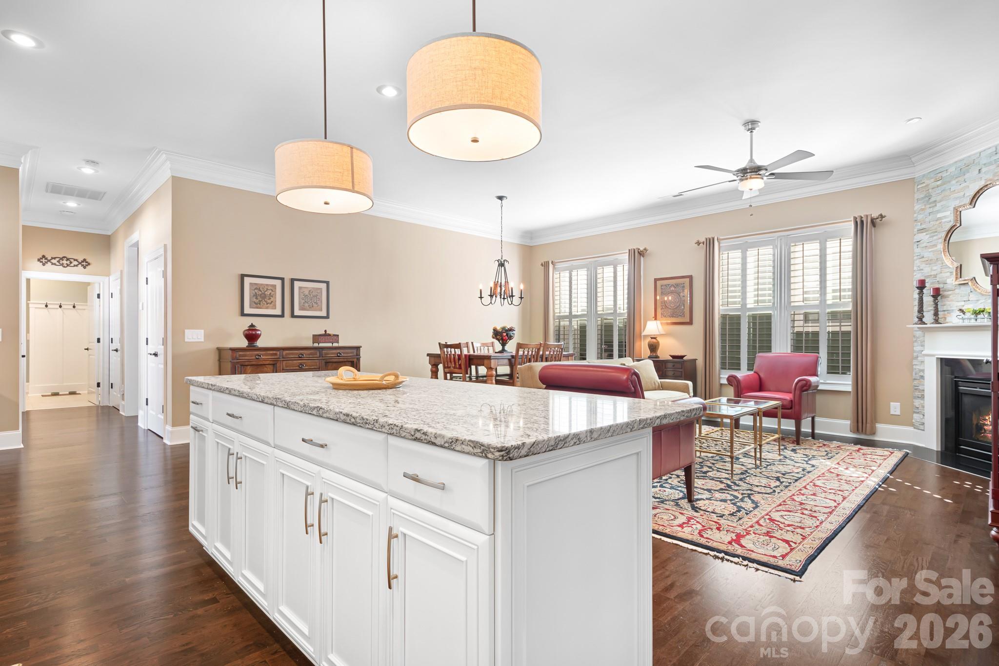 1215 Inn Keepers Way Cornelius, NC 28031 - Photo 2 of 35 a room with kitchen island a chandelier dining table and chairs