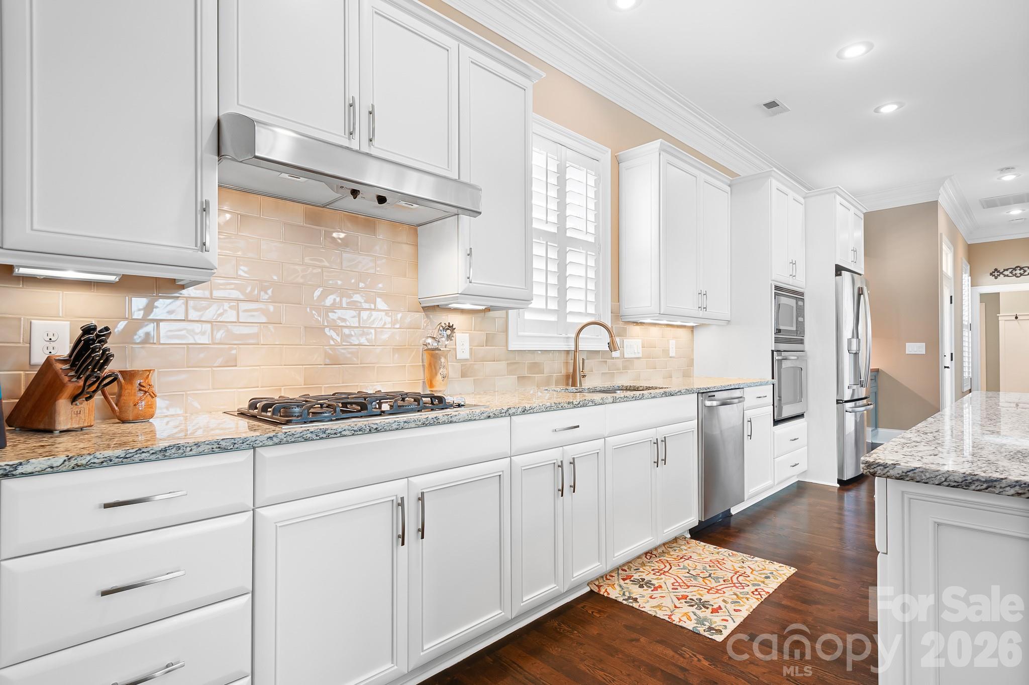 1215 Inn Keepers Way Cornelius, NC 28031 - Photo 3 of 35 a kitchen with granite countertop white cabinets and white appliances