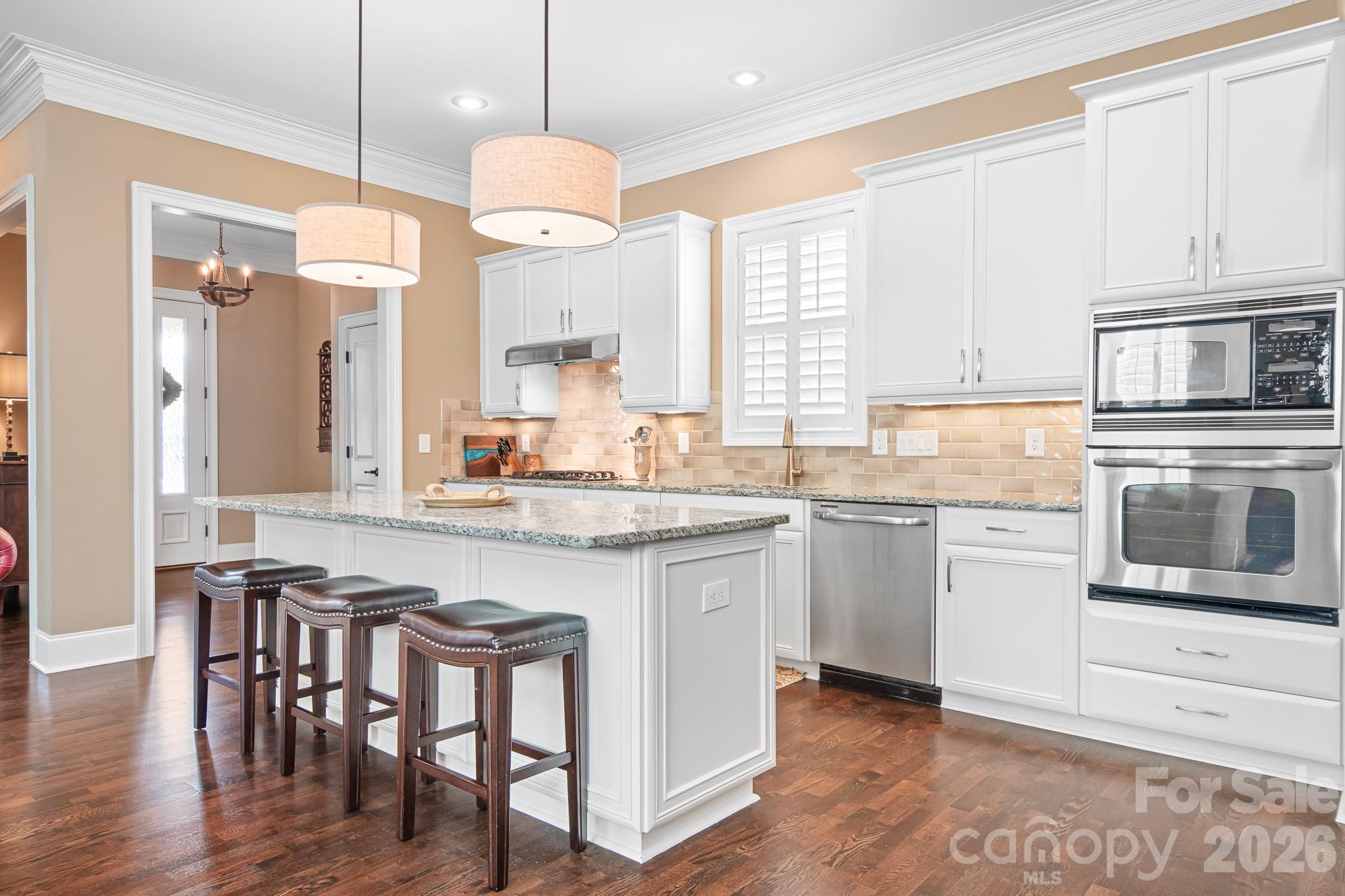 1215 Inn Keepers Way Cornelius, NC 28031 - Photo 5 of 35 a kitchen with granite countertop a stove a sink a dining table and chairs