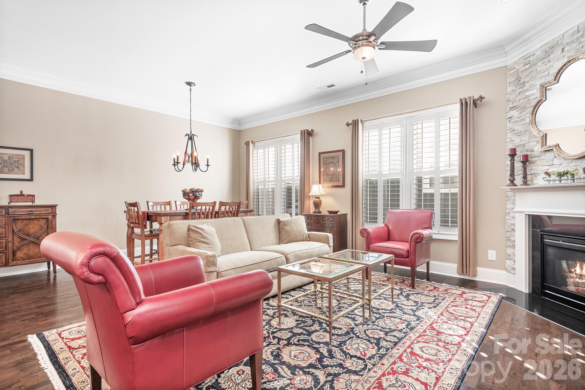 1215 Inn Keepers Way Cornelius, NC 28031 - Photo 6 of 35 a living room with furniture a fireplace and a chandelier