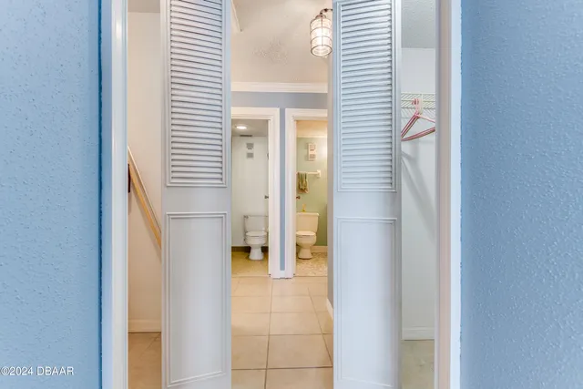 a view of a hallway with a white cabinet and a white door