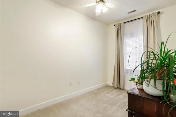 an empty room with potted plants and a window
