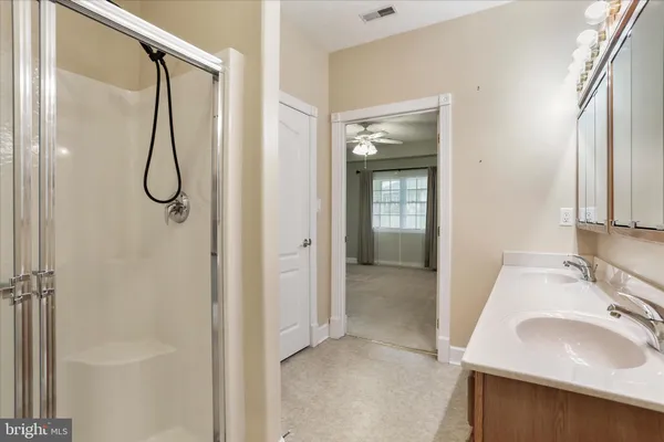 a bathroom with a granite countertop sink a shower and a mirror