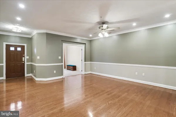 an empty room with wooden floor and bathroom