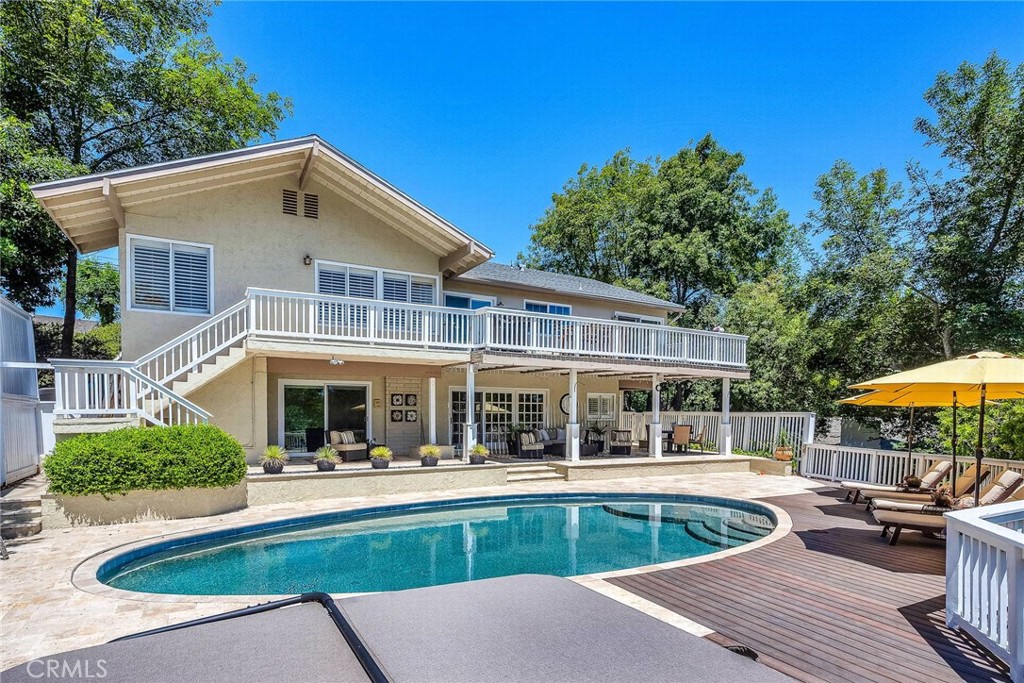 a view of a house with a swimming pool and sitting area