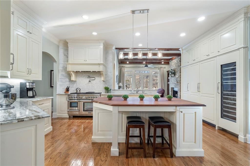 1665 High Trail Southeast Atlanta, GA 30339 - Photo 7 of 53 a kitchen with stainless steel appliances kitchen island granite countertop a stove a sink a refrigerator and white cabinets with wooden floor