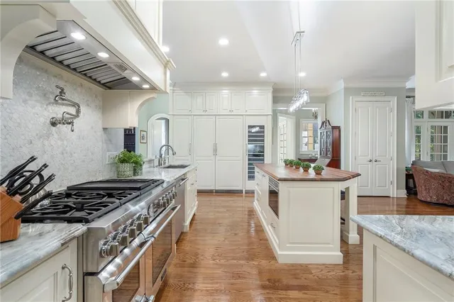 a kitchen with stainless steel appliances kitchen island granite countertop a stove and a sink