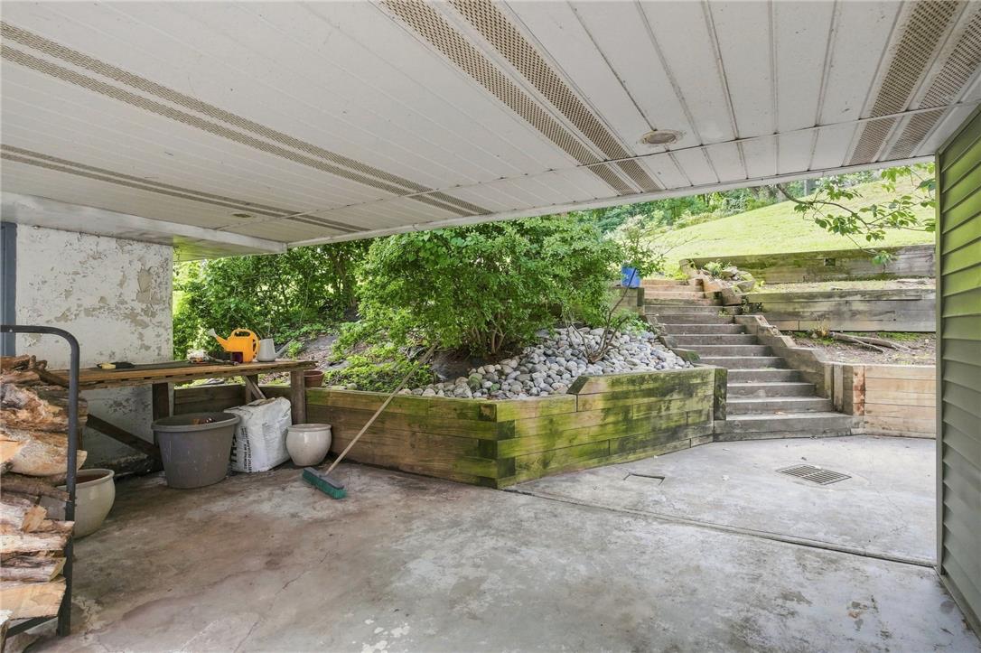 3408 Oak Hill Road Emmaus, PA 18049 - Photo 36 of 93 Sheltered concrete patio overlooks tiered wooden retaining walls and steps leading up the grassy slope.