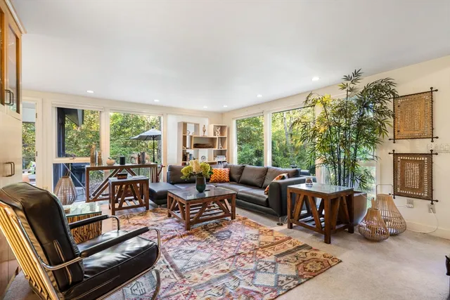 a living room with fireplace furniture and a large window