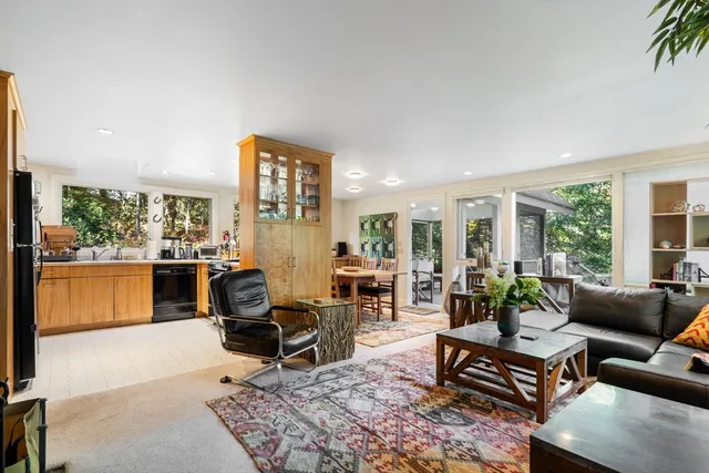 a living room with furniture a dining table and a floor to ceiling window
