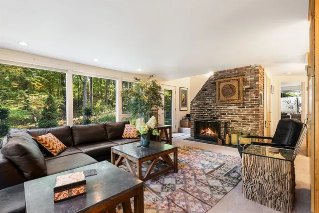 a living room with furniture a fireplace and large windows