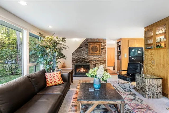 a living room with furniture a fireplace and potted plants