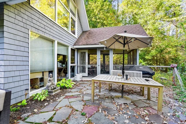 a view of a patio with table and chairs under an umbrella