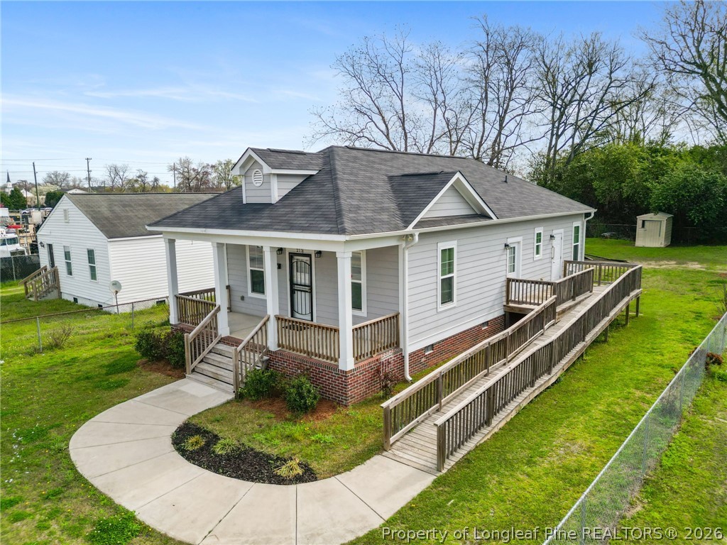 215 Old Wilmington Road Fayetteville, NC 28301 - Photo 2 of 31 a front view of a house with a yard table and chairs