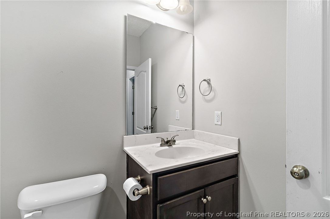 215 Old Wilmington Road Fayetteville, NC 28301 - Photo 21 of 31 a bathroom with a toilet a sink and a mirror