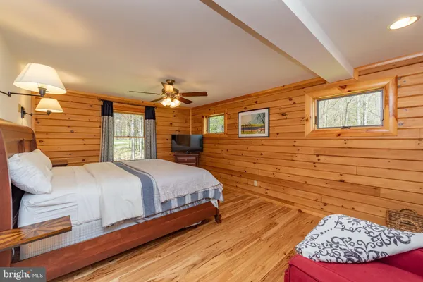 a bedroom with a large bed and a flat tv screen on dresser