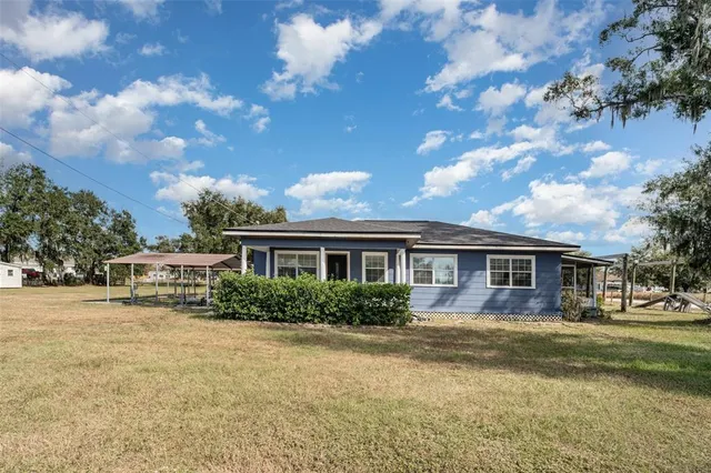 a front view of house with yard and trees around