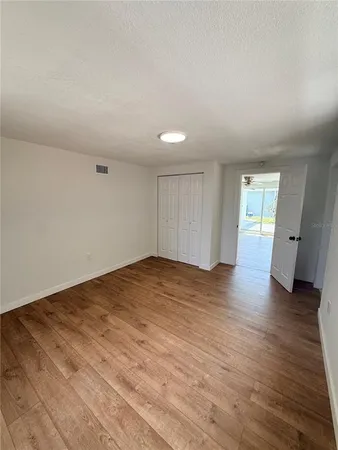 a view of empty room with wooden floor and window