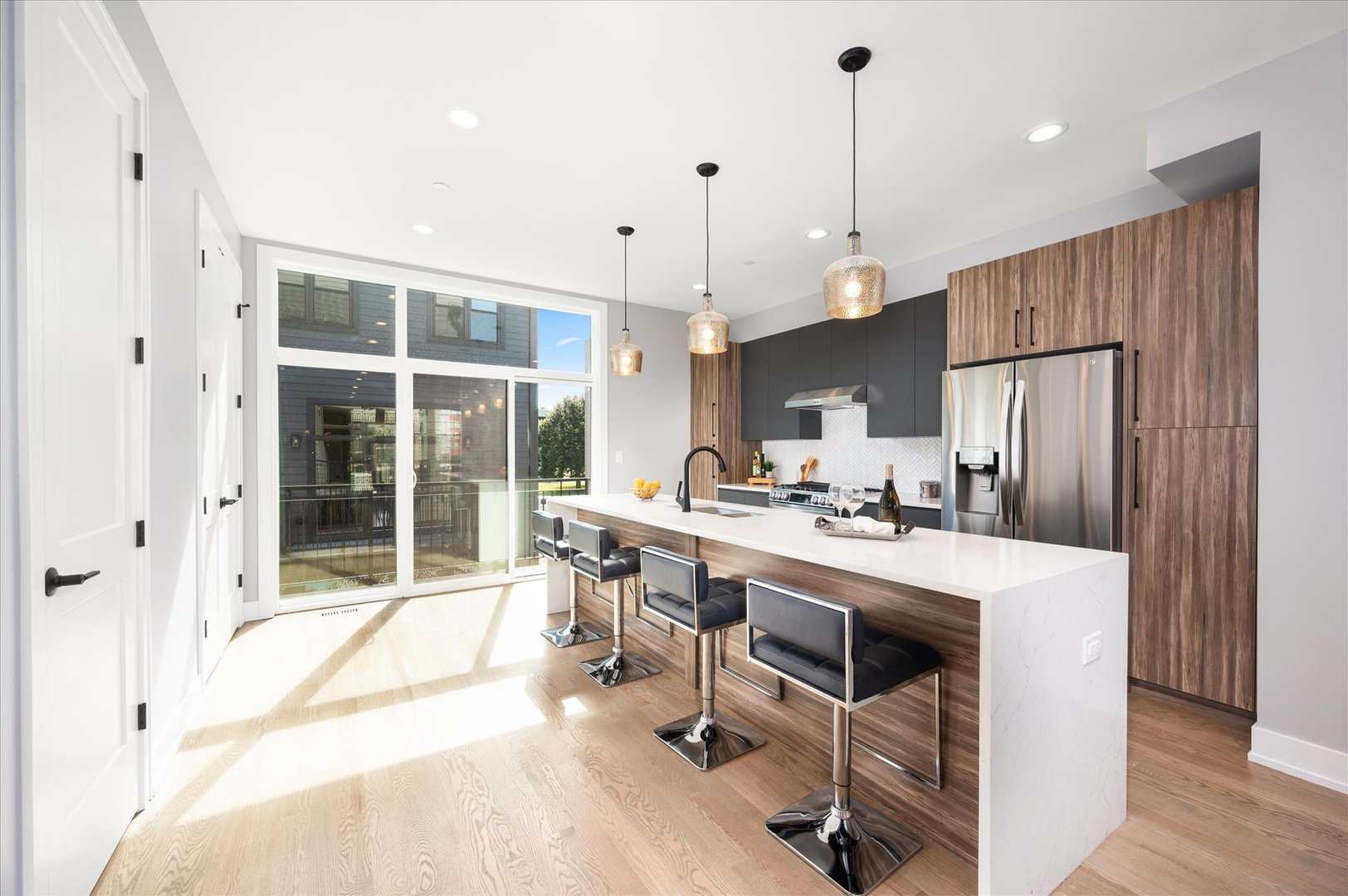 4438 South Drexel Boulevard, Unit D Chicago, IL 60653 - Photo 9 of 29 a view of a kitchen with kitchen island a dining table chairs and a wooden floor