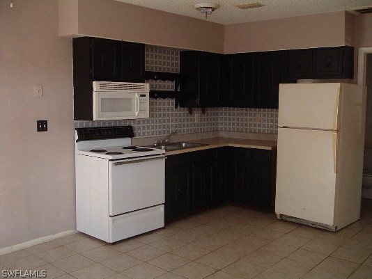 3255 Stringfellow Road St. James City, FL 33956 - Photo 11 of 16 a kitchen with a sink and a refrigerator