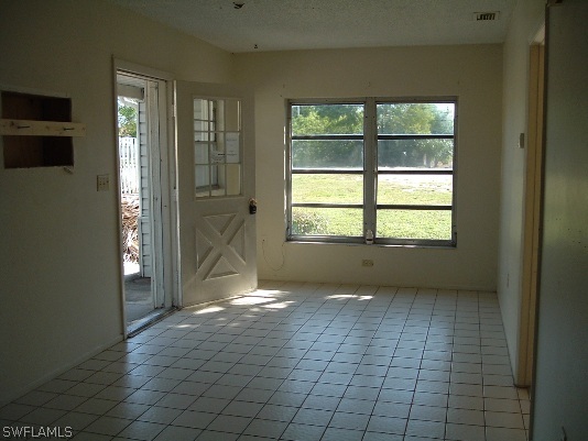 3255 Stringfellow Road St. James City, FL 33956 - Photo 7 of 16 an empty room that has a window in it