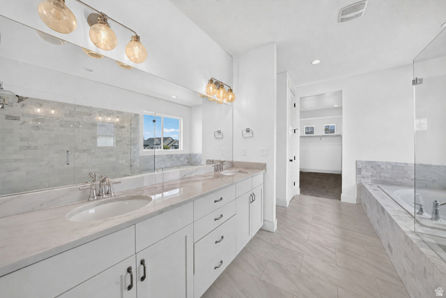 1002 West Temple Rim Lane Payson, UT 84651 - Photo 30 of 68 Dual vanity with white cabinetry and light-toned countertops, featuring a full-width mirror and contemporary lighting fixtures