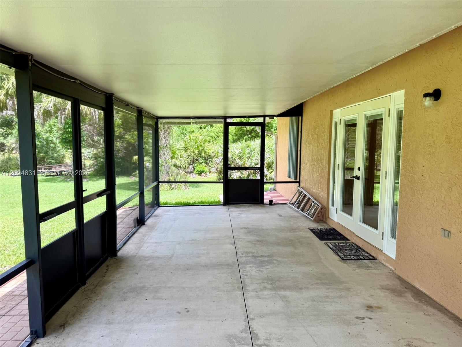 15819 76th Road North Loxahatchee, FL 33470 - Photo 30 of 45 a view of porch with a floor to ceiling window next to a yard