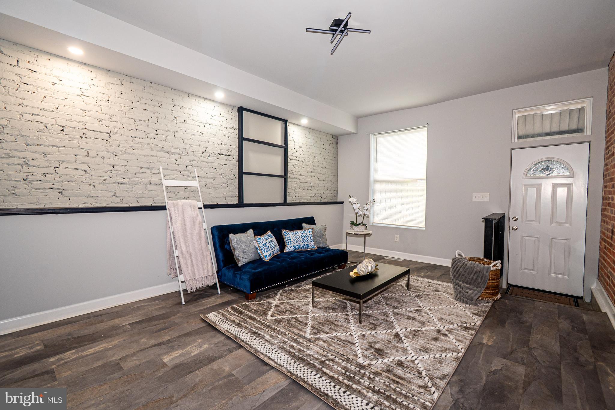 3103 East Monument Street Baltimore, MD 21205 - Photo 3 of 20 a living room with furniture and wooden floor