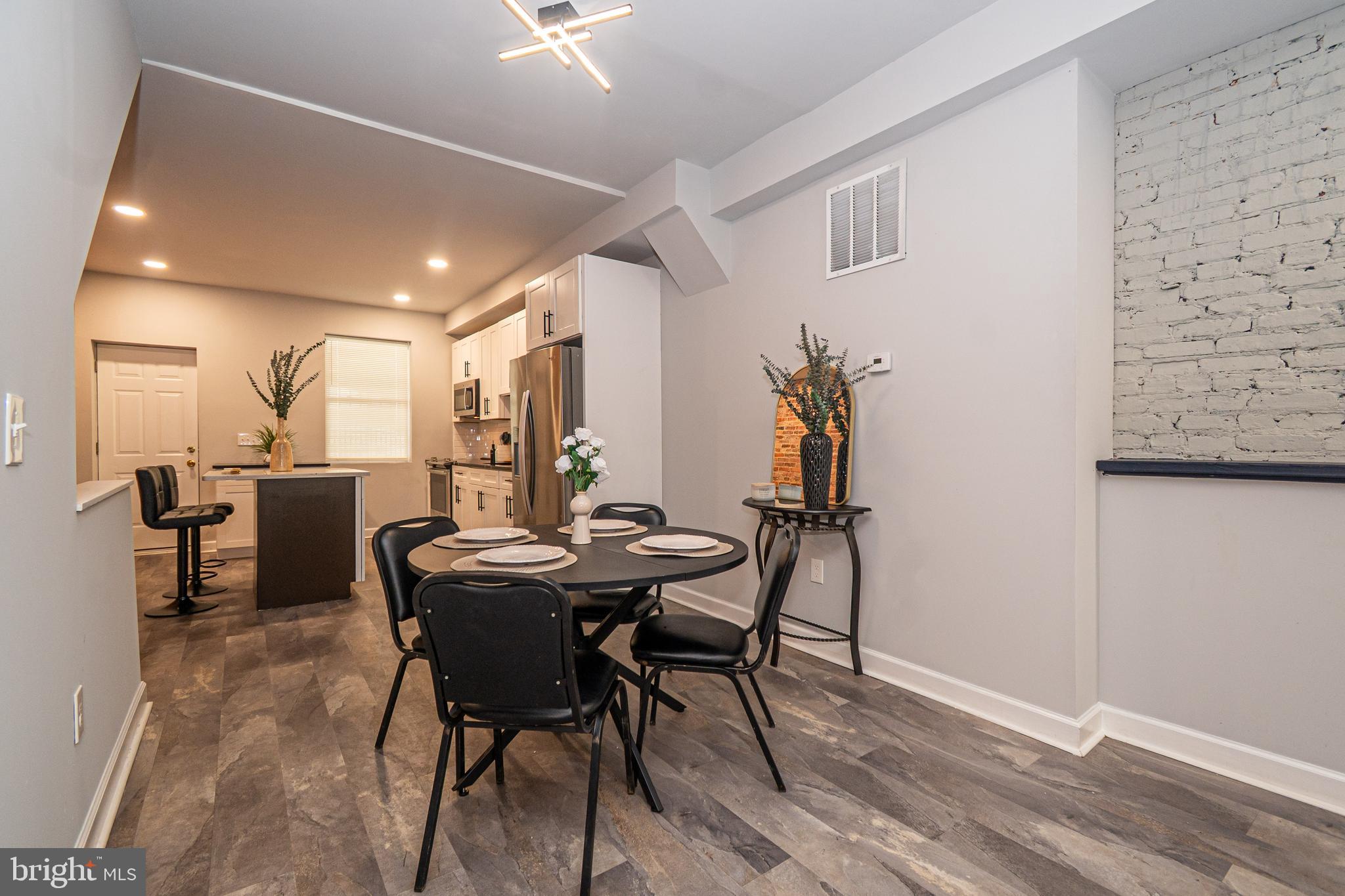3103 East Monument Street Baltimore, MD 21205 - Photo 4 of 20 a view of a dining room with furniture and wooden floor