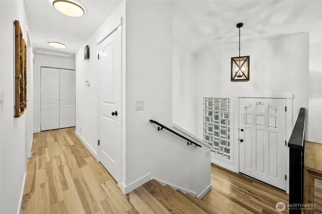 a view of a hallway with wooden floor and stairs