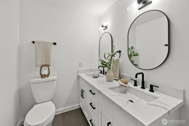 a bathroom with a toilet a sink a mirror and vanity