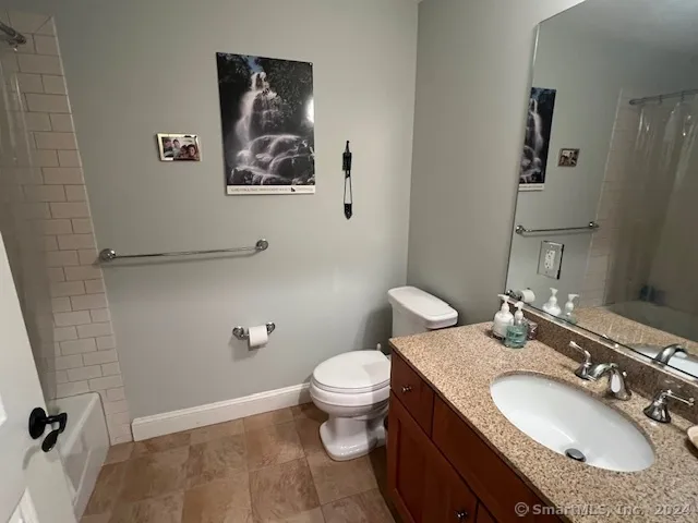 a bathroom with a granite countertop toilet a sink and mirror