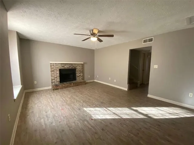 an empty room with windows and fireplace