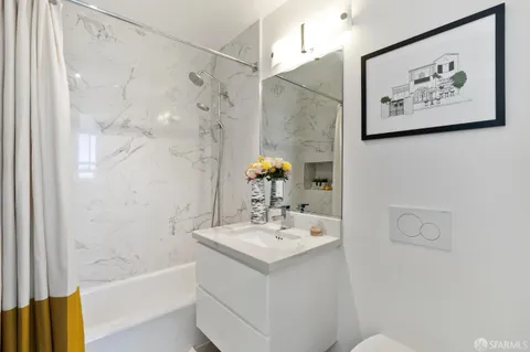 a bathroom with a sink mirror and a bath tub