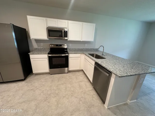 a kitchen with granite countertop a sink and a stove top oven