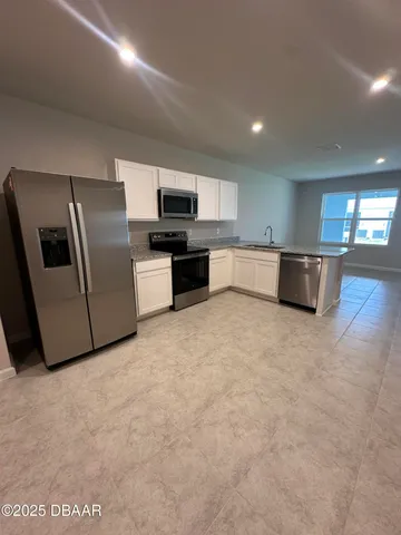 a large kitchen with stainless steel appliances a large counter top