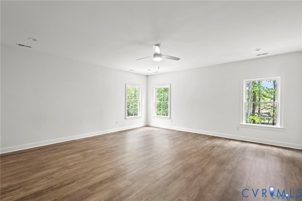 4927 Gooden Trail Quinton, VA 23141 - Photo 16 of 22 an empty room with wooden floor chandelier fan and windows